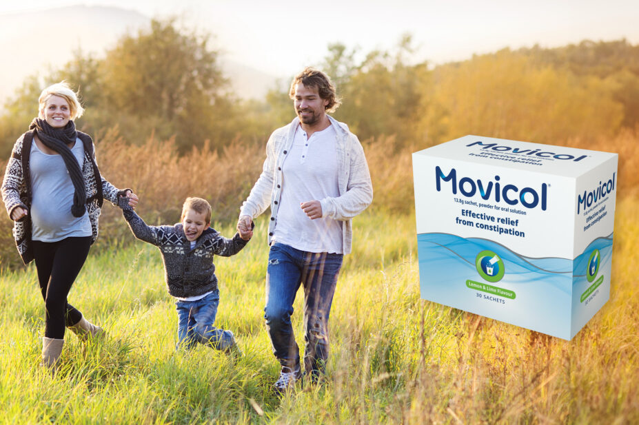Photo of a family walking through an autumnal field, with a pregnant mother, child and father, and the new Movicol packaging on the right hand side of the image