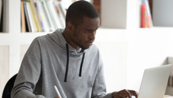 Black male student using laptop