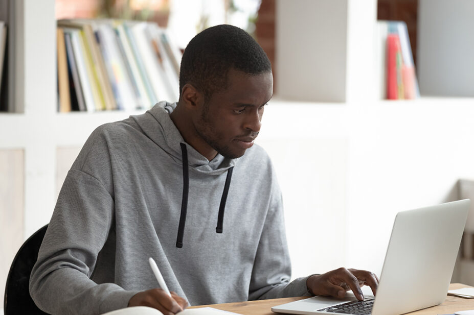 Black male student using laptop
