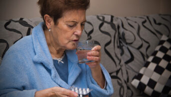 Older woman taking medicine