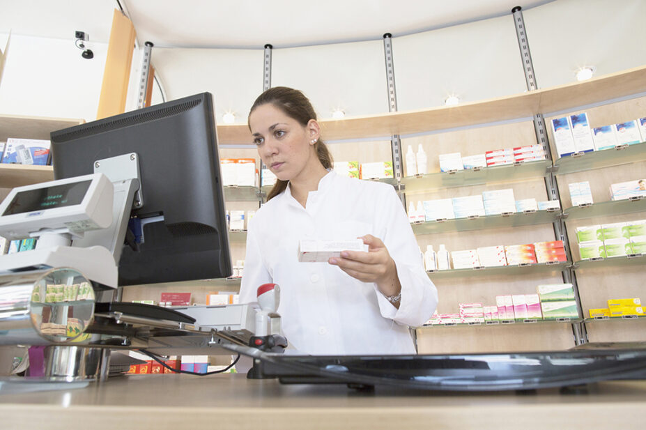 Pharmacist in pharmacy using computer