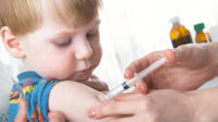 young boy receiving injection in upper arm