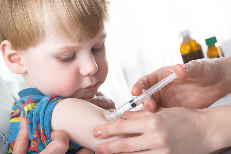young boy receiving injection in upper arm