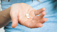 hand holding white pills