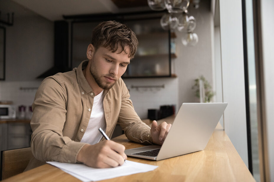 Adult male sitting at laptop at home studying