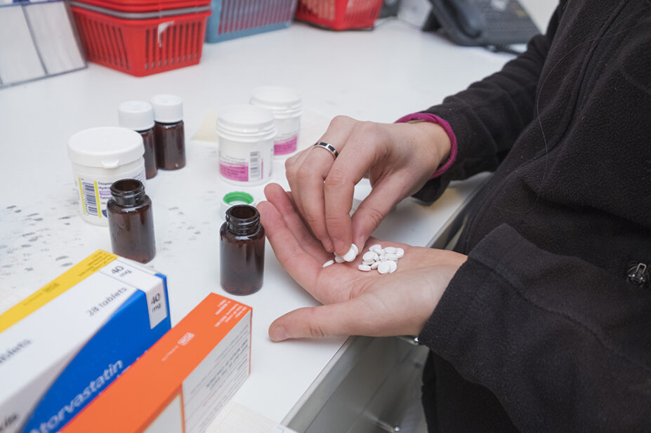 Pharmacy technician preparing prescriptions at a pharmacy.