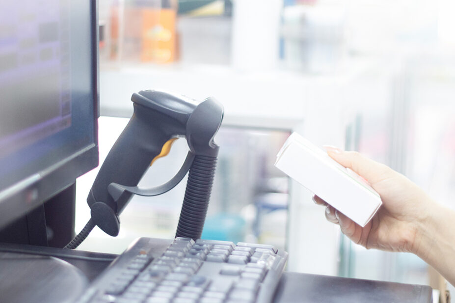 Pharmacist scanning medicine at pharmacy till