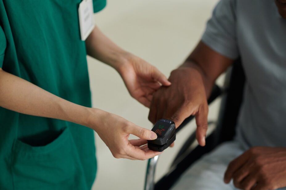 Photo of an oxymeter device on finger of sick patient
