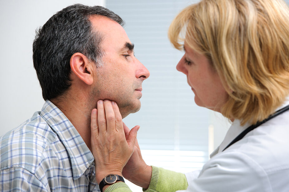 healthcare professional touching patient's throat to examine it
