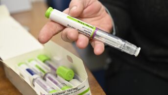 Person holding a Tocilizumab pen-like autoinjector