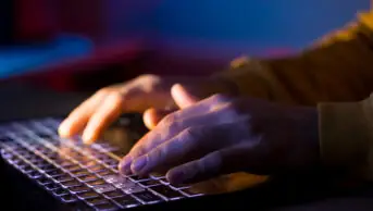 hands typing on a laptop keyboard