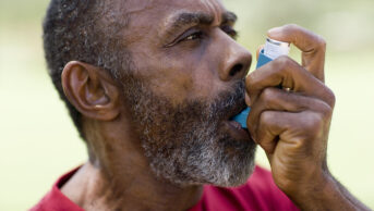 man using asthma inhaler