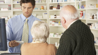 older couple at pharmacy counter with pharmacist
