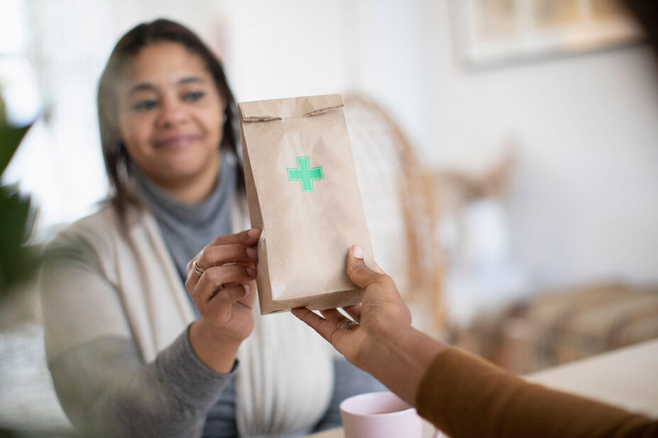 Woman collecting prescription bag from pharmacist