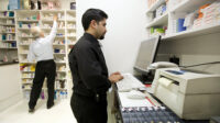 Pharmacist using computer in pharmacy