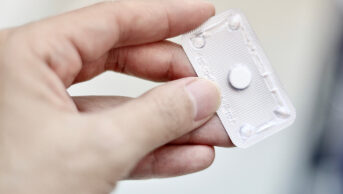 hand holding emergency contraceptive pill in blister pack