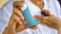 Older woman holding inhaler