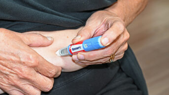 woman injecting ozempic into stomach