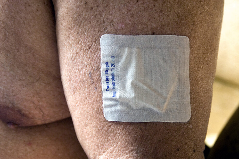 Transdermal buprenorphine patch on the arm of an older man