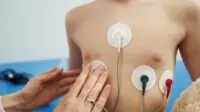 Doctor checking child heart rhythm with ECG halter monitor