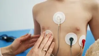 Doctor checking child heart rhythm with ECG halter monitor