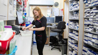 Pharmacist organising prescriptions in a dispensary
