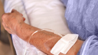 Someone with IV infusion in their arm