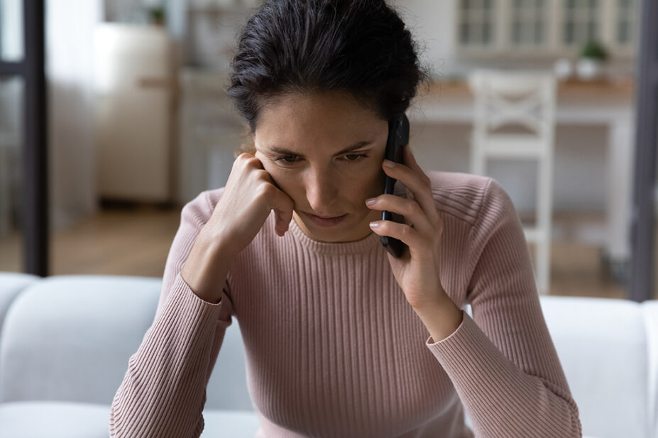 woman on phone resting head on hand