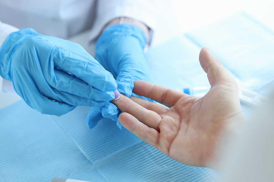 Close up of clinician carrying out finger prick test to identify diabetes