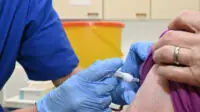 Someone being given an intramuscular injection by a healthcare professional