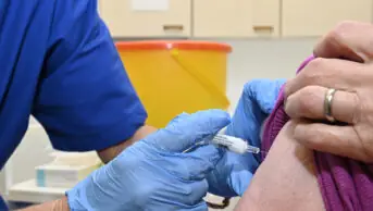 Someone being given an intramuscular injection by a healthcare professional