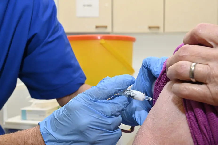 Someone being given an intramuscular injection by a healthcare professional