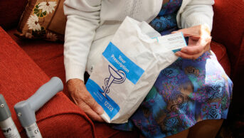 Older woman opening prescription bag