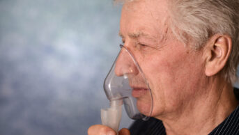 Older man wearing nebuliser