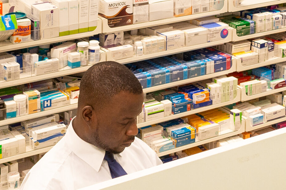 Pharmacist standing behind pharmacy counter