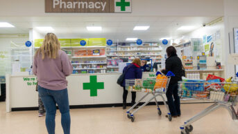 Customers queuing at a Tesco pharmacy counter