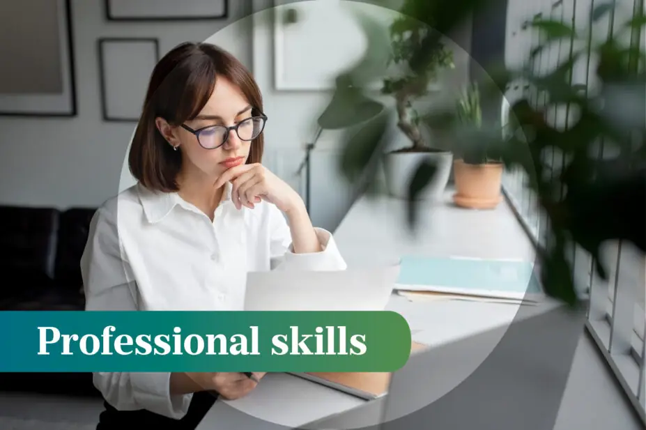 Photo of a woman looking at a paper and a laptop in an office