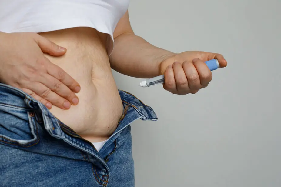 Woman uses injection pen on her stomach