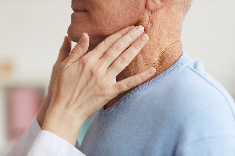 Clinician checking someone's throat and neck