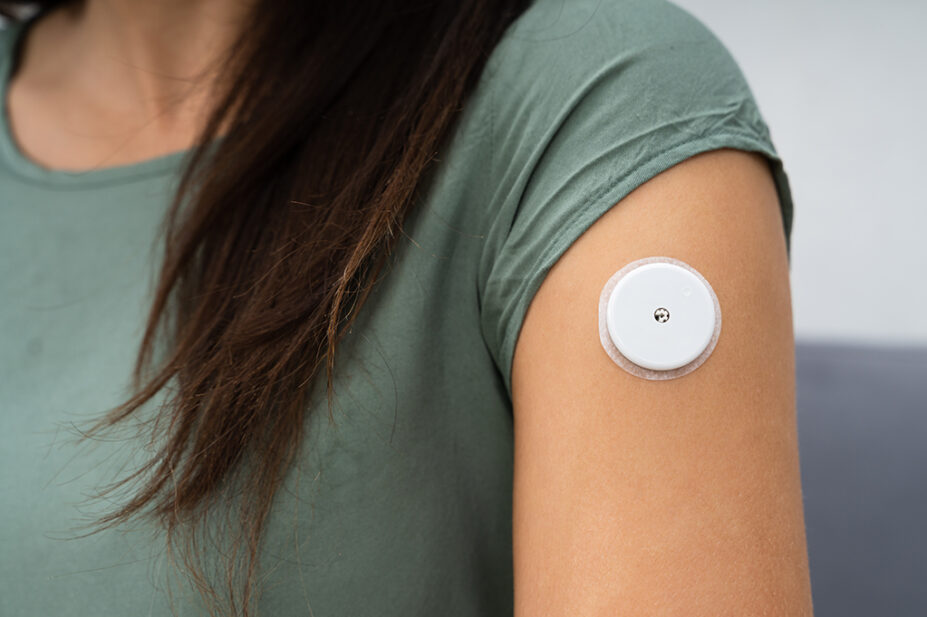 Close up of a glucose monitor on someone's arm