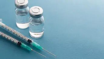 Syringes and medicine bottles on a blue background