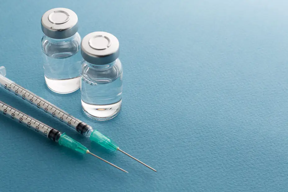 Syringes and medicine bottles on a blue background