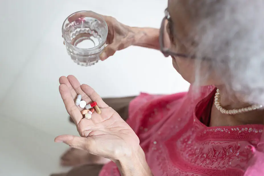 Older woman taking medicines