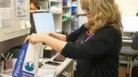 Photo of a pharmacist packing a prescription