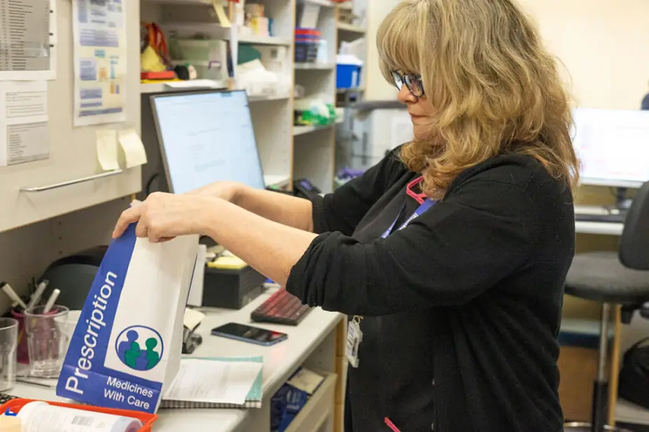 Photo of a pharmacist packing a prescription