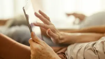 Older woman using tablet at home, suggestive of internet pharmacy