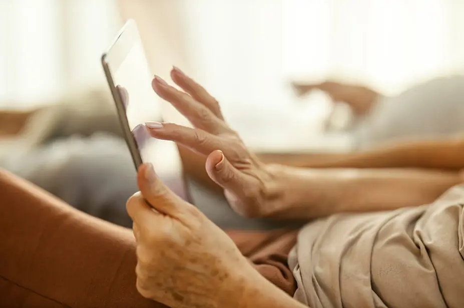 Older woman using tablet at home, suggestive of internet pharmacy