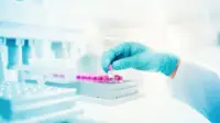 Scientist holds genetic sample in a vial