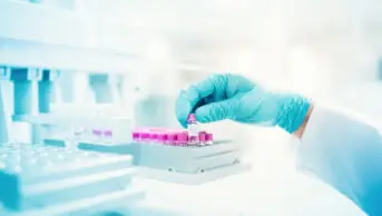 Scientist holds genetic sample in a vial