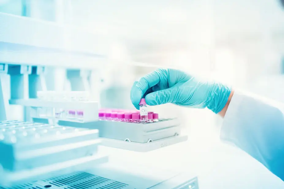 Scientist holds genetic sample in a vial